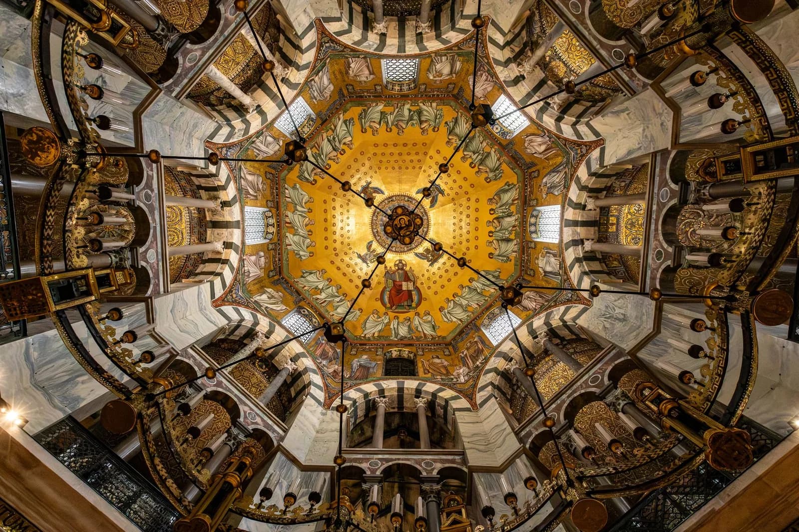 Coupole en mosaïque dorée de l'octogone de la cathédrale d'Aix-la-Chapelle, vue en contre-plongée avec le lustre de Barberousse