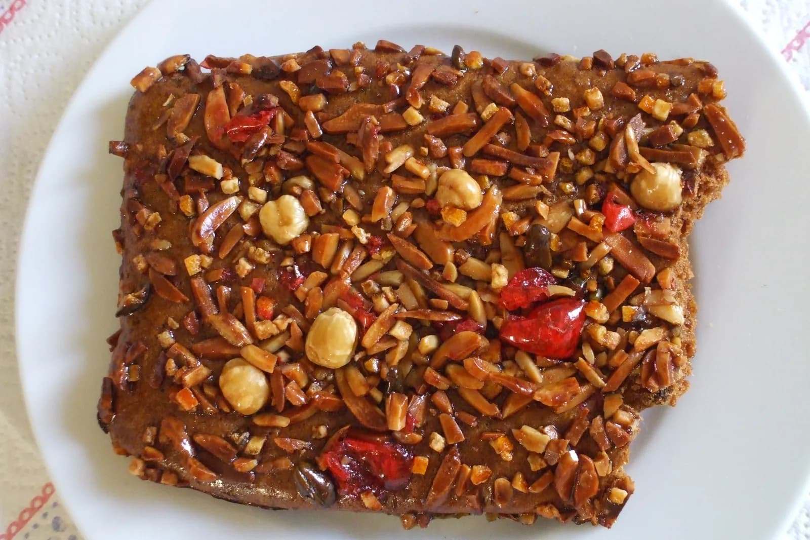 Plaque d'Aachener Printen, pain d'épices rectangulaire brun garni d'amandes effilées, de noisettes et de fruits confits