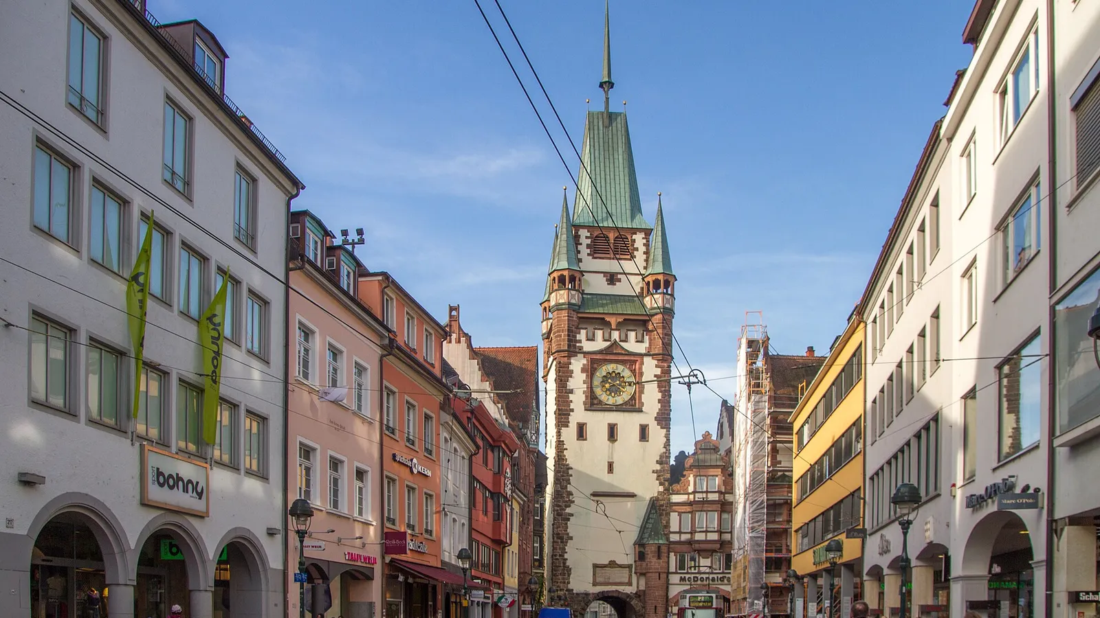 La porte médiévale Martinstor au bout d'une rue commerçante de Fribourg-en-Brisgau