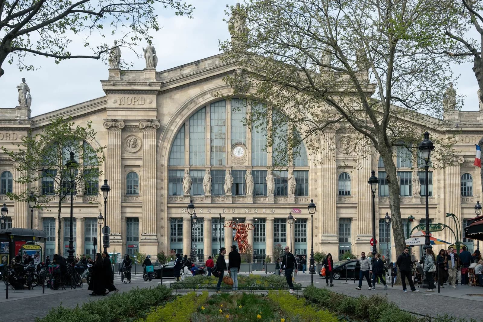 Façade de la gare du Nord à Paris, avec sa grande verrière et ses statues, vue depuis le parvis